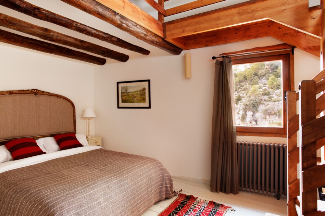 Потолок над кроватью можно дополнить оригинальным деревянным декором