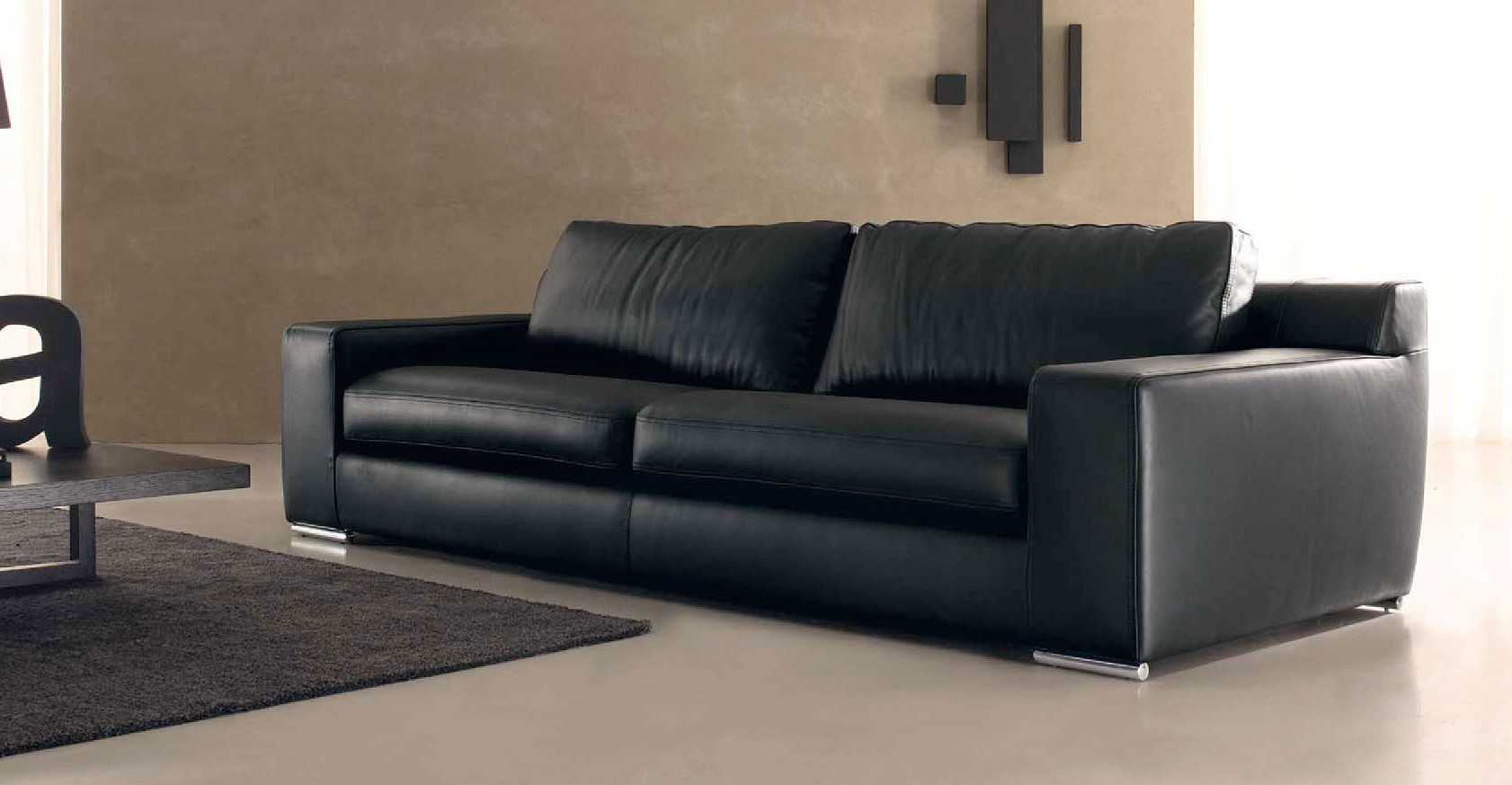 Черный диван из кожзама с металлическими ножками идеально подойдет под современный интерьер