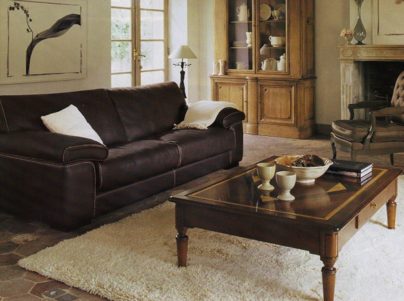 На темно-коричневый диван можно выложить светлую подушку и плед