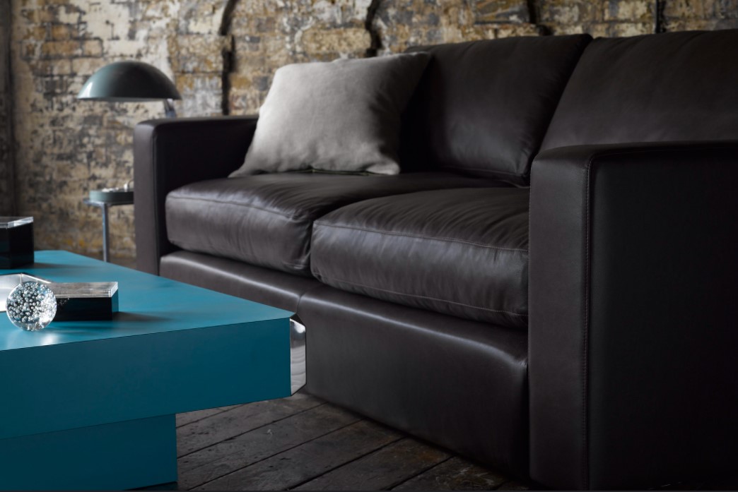 Черный диван из искусственной кожи идеально подойдет для интерьера в стиле лофт