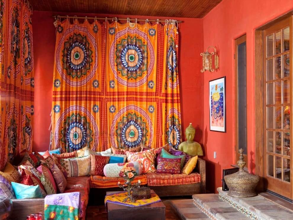 Обилие текстиля, низкие диваны и насыщенный теплый цвет стен создают этническую атмосферу в гостиной.