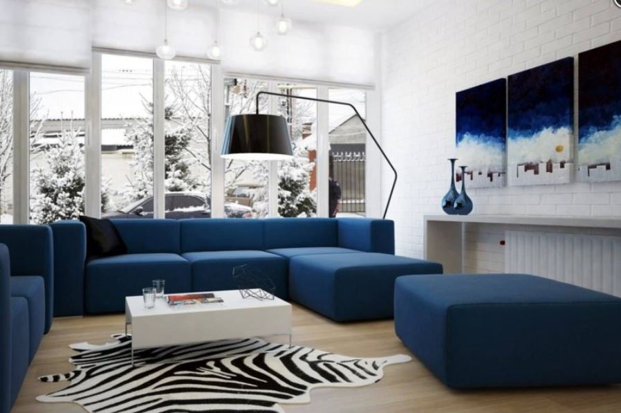 Синий диван в белой гостиной - отличный выбор для южного расположения комнаты