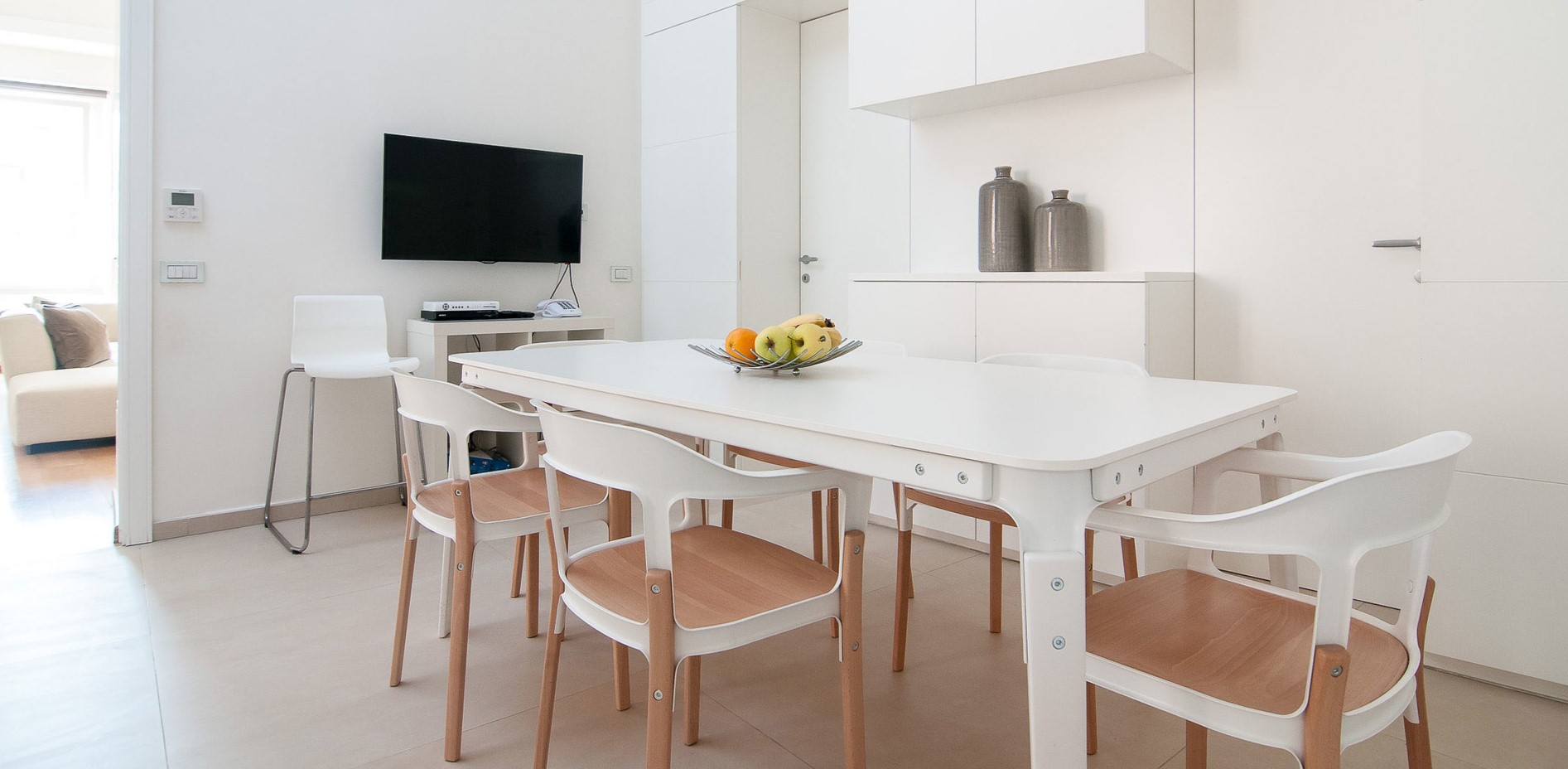 Белые стулья с деревянными вставками дополнят скандинавский интерьер кухни