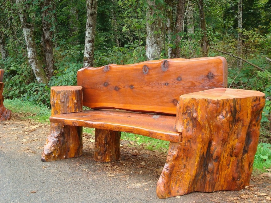Скамейка из грубых бревен в парке.