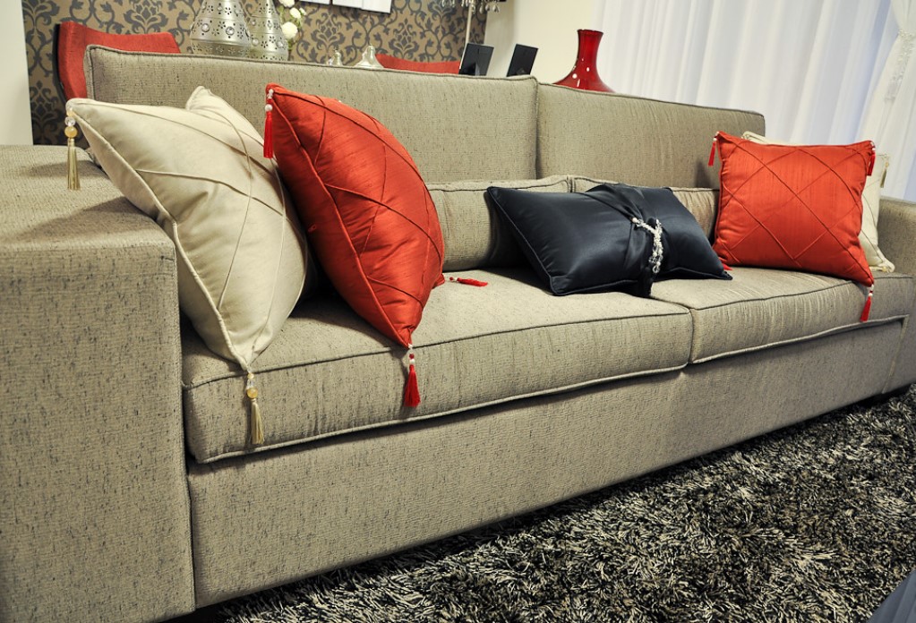 Дополнить светлый однотонный диван можно яркими подушками