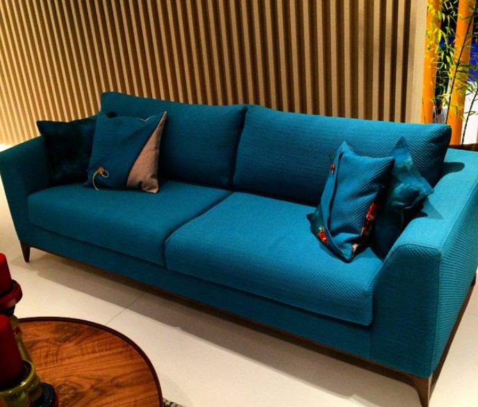 Синий диван можно дополнить подушками с рисунками