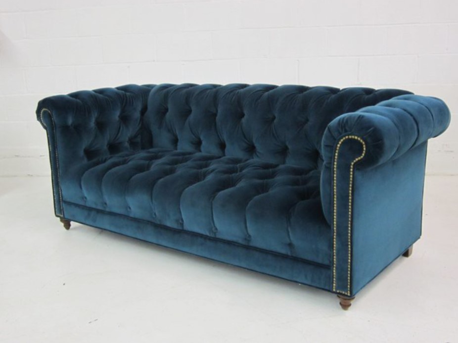Синий диван с текстильной обивкой подойдет для светлой комнаты