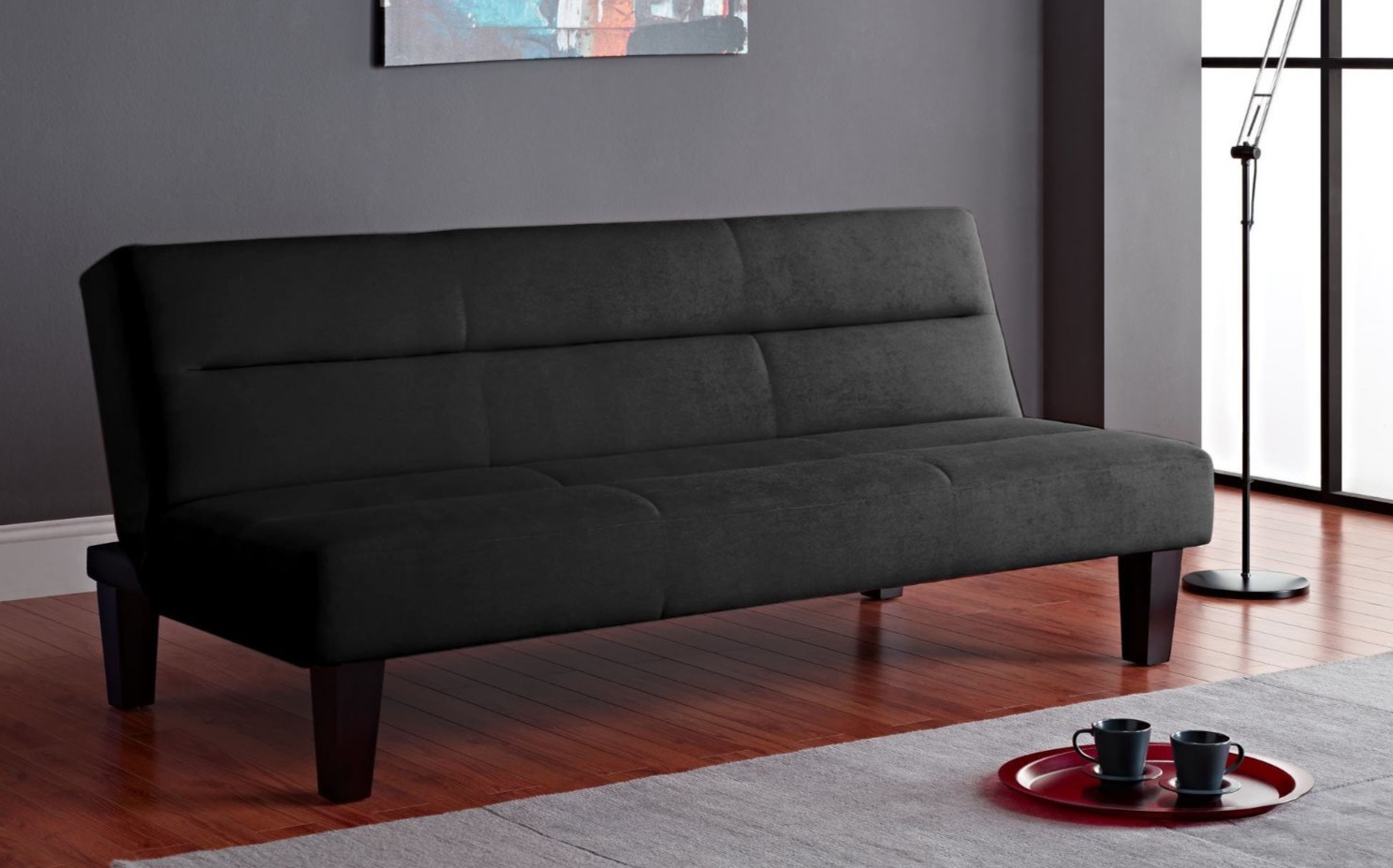 Черный диван с деревянными ножками подойдет для интерьера современной гостиной