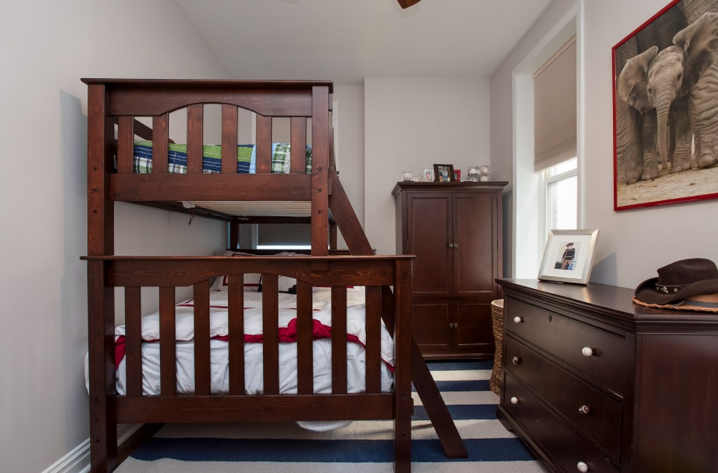 В маленькую детскую комнату можно вместить двухуровневую кровать, комод и шкаф