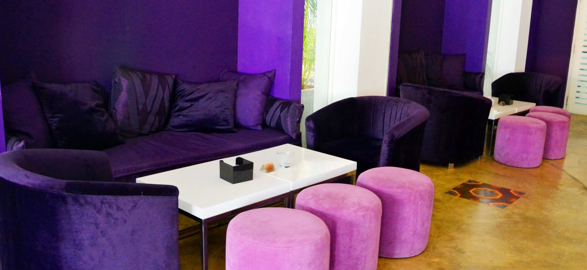 Для декора интерьера можно использовать сиреневые пуфики и фиолетовые диваны