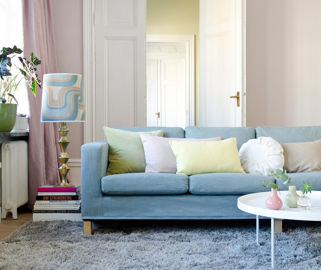 Интерьер с голубым диваном в пастельных тонах.
