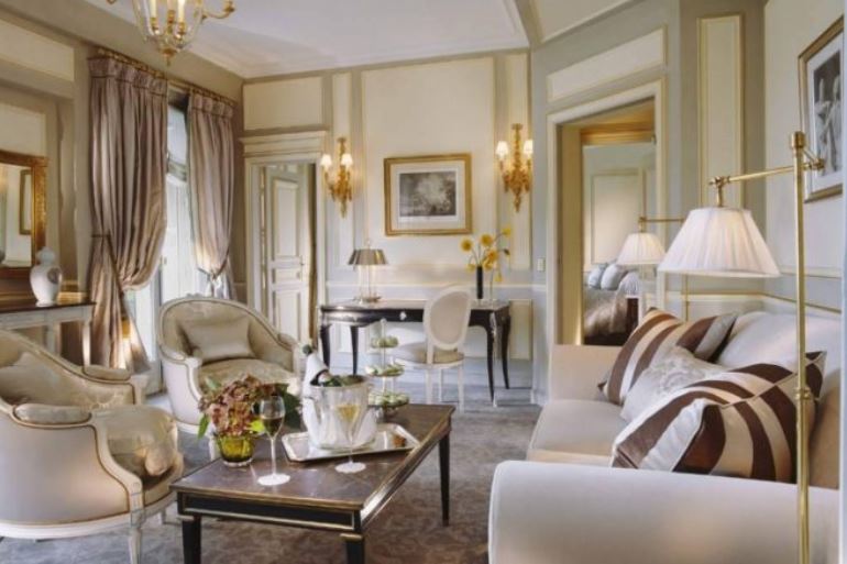 Современные торшеры мило соседствуют со стилизованными под старину бра и люстрой во французской гостиной