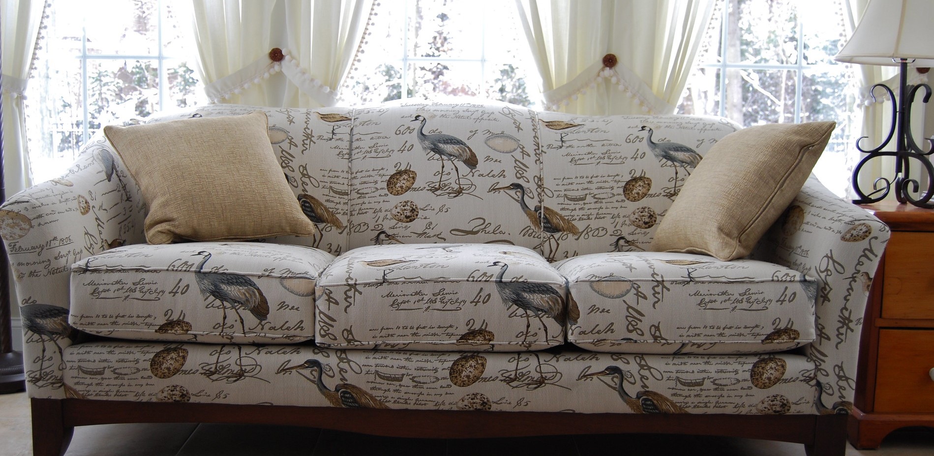 Стильный диван с тканевой обивкой и деревянными ножками