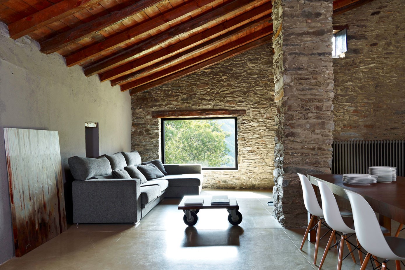 В частном доме можно оформить стены камнем, а на потолке сделать деревянные балки