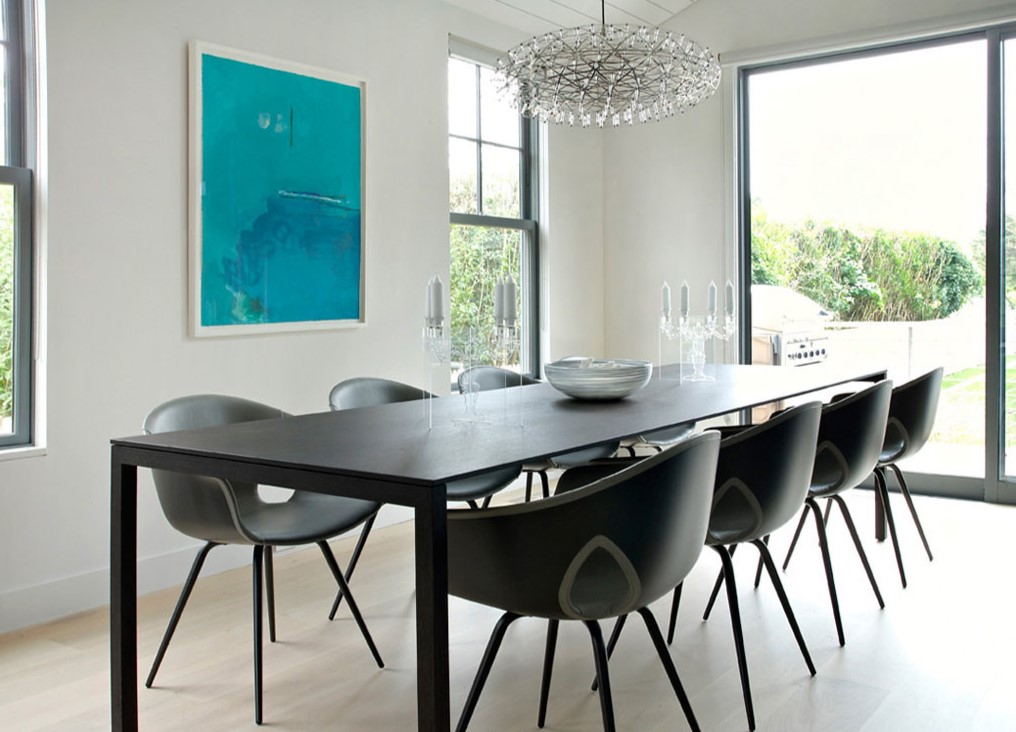 Обеденный стол и стулья черного цвета идеально подходят под белый интерьер столовой