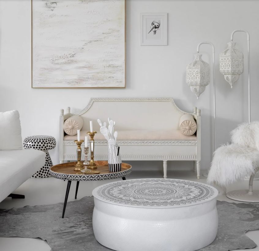 В бело-серой гамме выделяется светло-персиковый диван и металлическая столешница кофейного столика