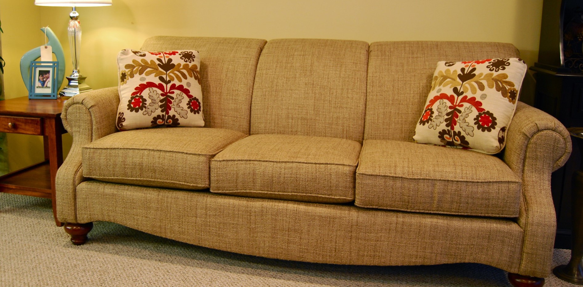 Однотонный гобеленовый диван можно дополнить подушками с рисунком