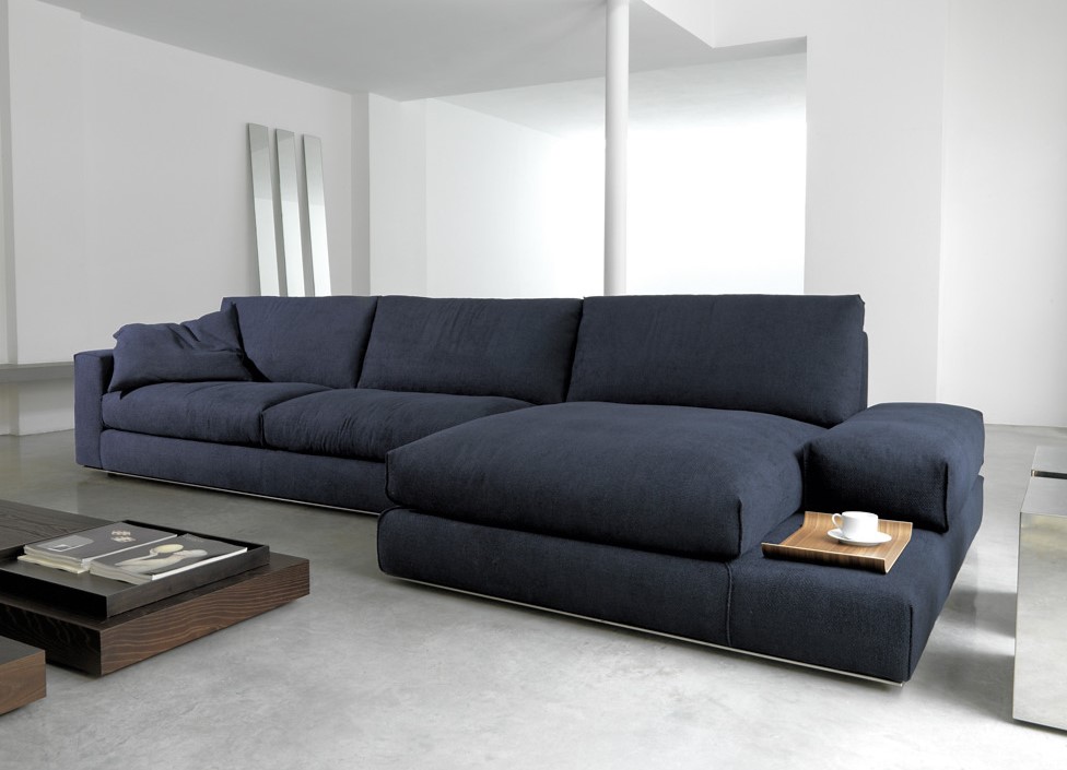 Синий диван с обивкой из флока стильно смотрится в интерьере белой гостиной