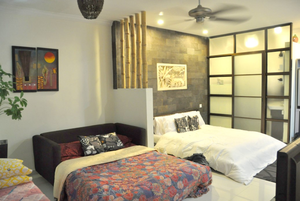 С помощью перегородки с бамбуковым декором можно выделить два спальных места в одной комнате