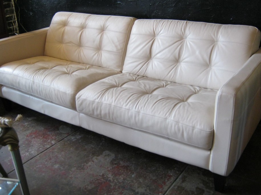 Белый кожаный диван будет оригинально смотреться в темном интерьере в стиле лофт