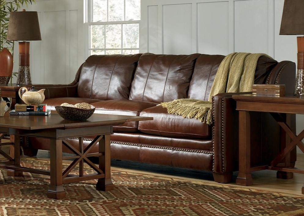 Темно-коричневый кожаный диван отлично гармонирует с мебелью из дерева