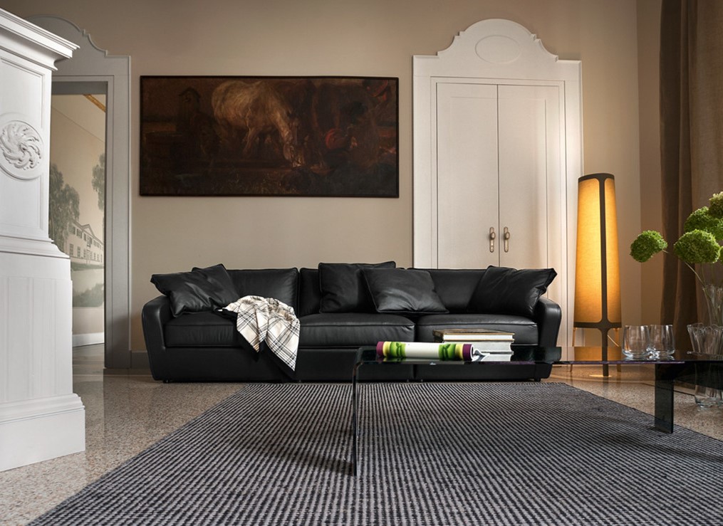 Черный кожаный диван в интерьере современной гостиной
