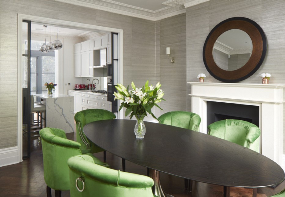 Высокий черный стол прекрасно гармонирует с зелеными креслами в интерьере