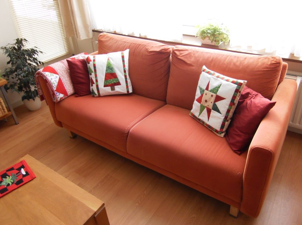 Для декора дивана можно использовать подушки и плед с новогодними рисунками