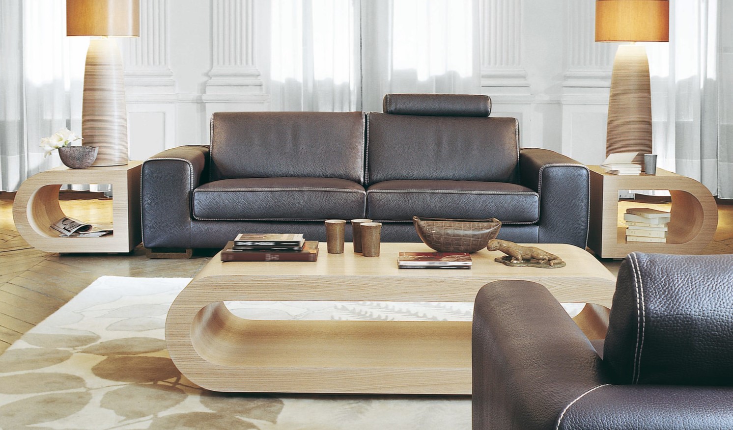 Темно-коричневый диван из натуральной кожи отлично дополняет светлый интерьер гостиной