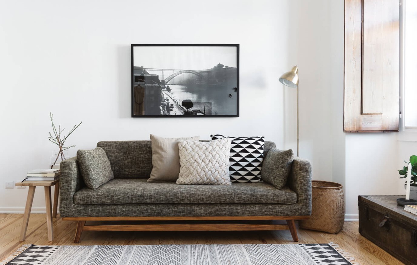 Серый диван с деревянным основанием в скандинавском интерьере 