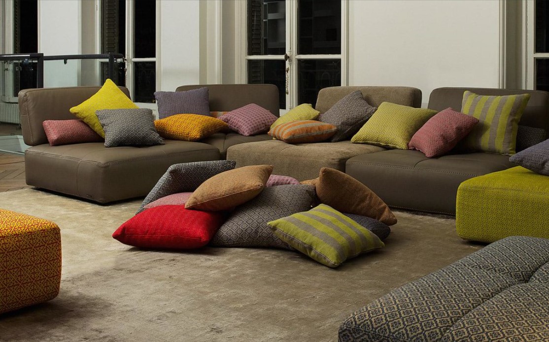 Однотонный диван можно дополнить яркими цветными подушками в качестве декора