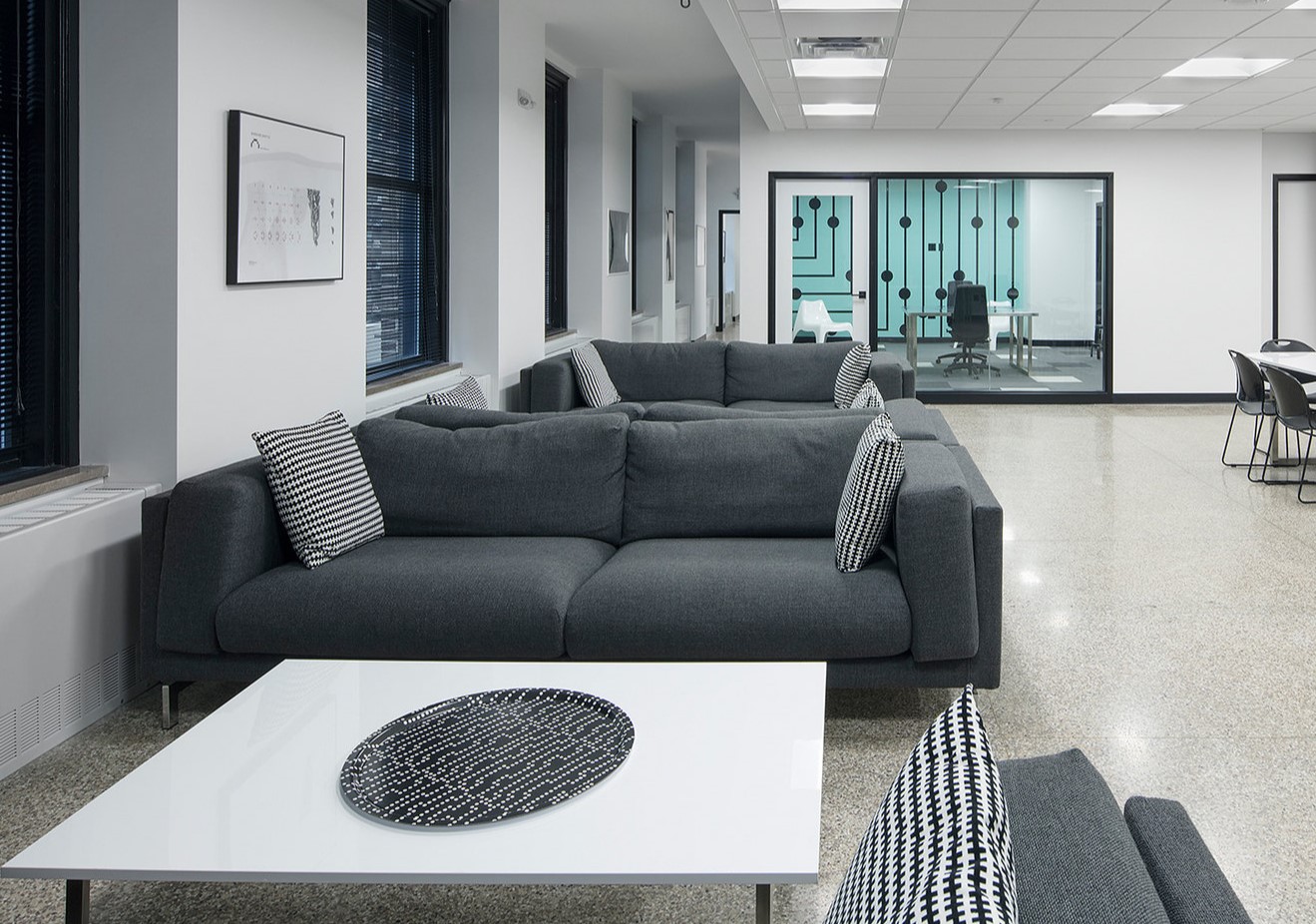Темно-серый диван прекрасно дополняет интерьер современного офиса