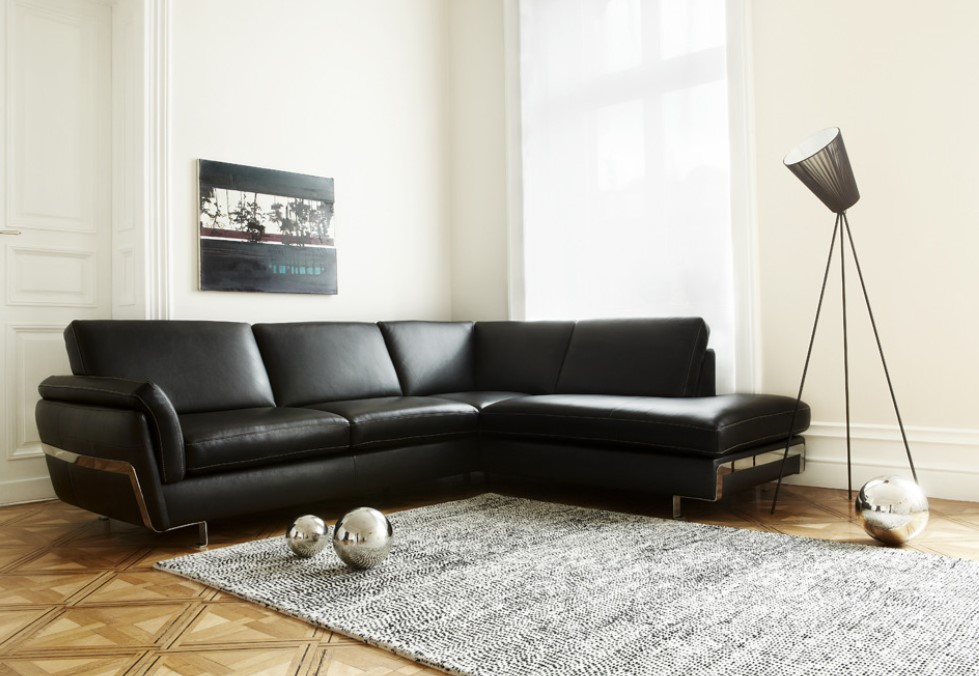 Черный кожаный диван прекрасно дополняет современный интерьер гостиной