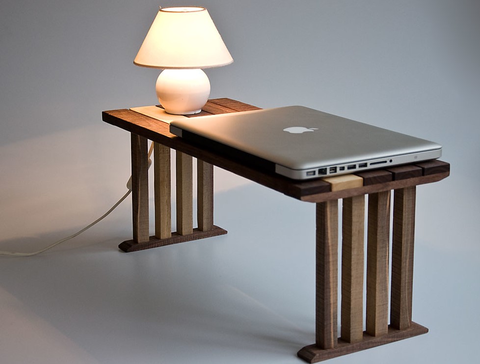 На небольшом деревянном столике можно разместить ноутбук и лампу в спальне