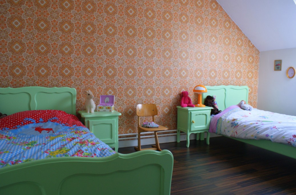 Яркие кровати в стиле ретро отлично сочетаются с обоями в интерьере детской комнаты