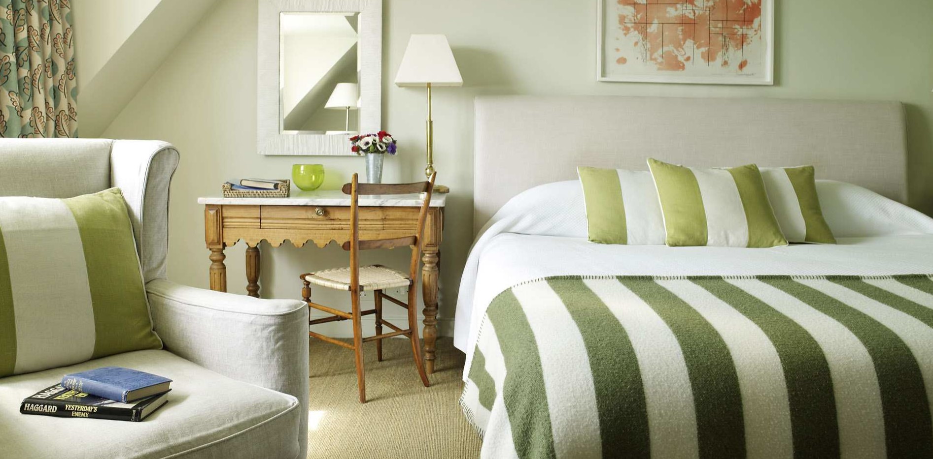 Постельное белье с полосками и винтажный столик помогут создать атмосферу ретро в интерьере спальни