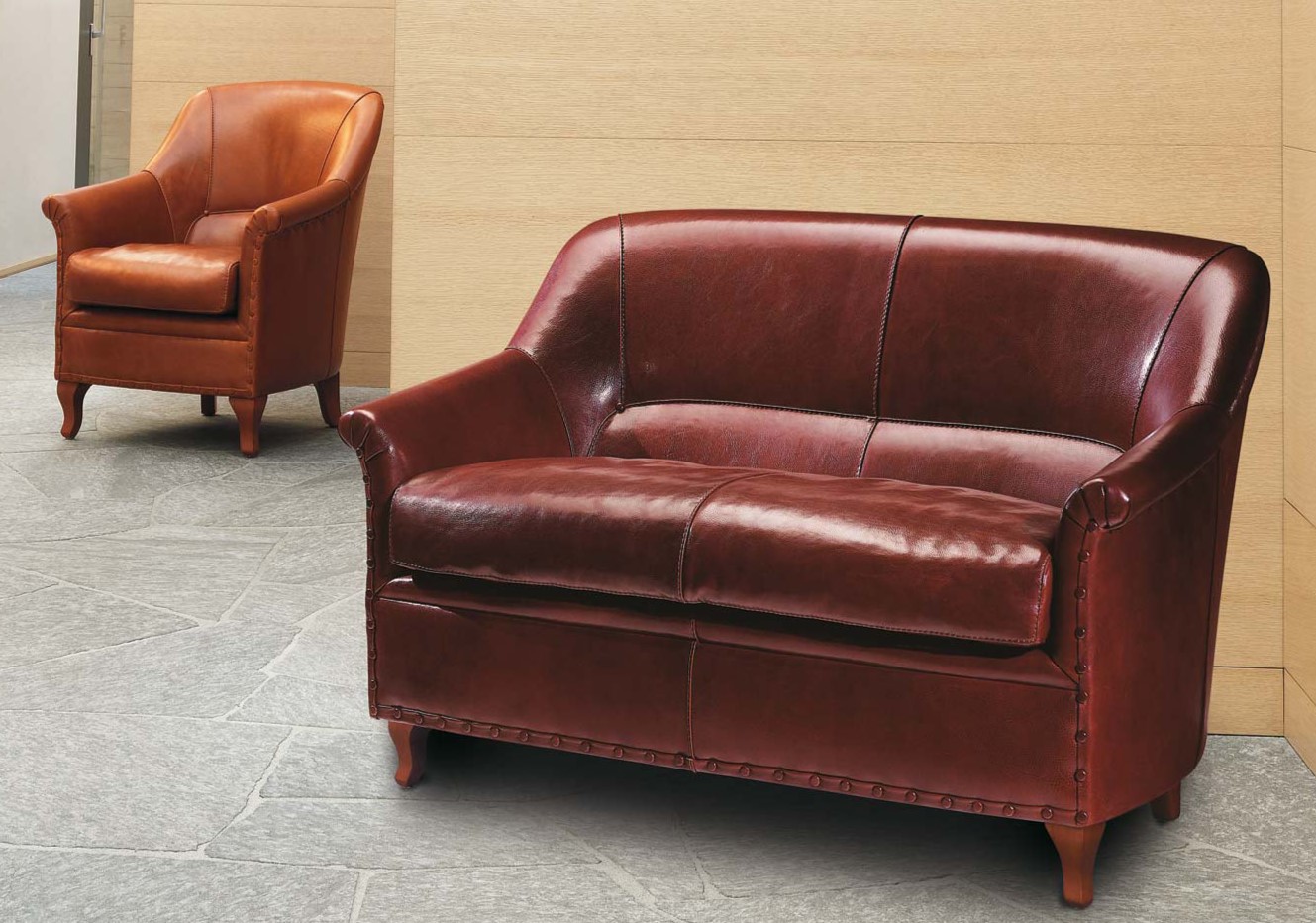 Небольшой кожаный диван можно отлично комбинировать с креслом в интерьер