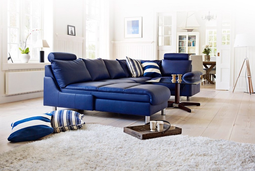 Синий диван станет акцентным элементом в белой гостиной