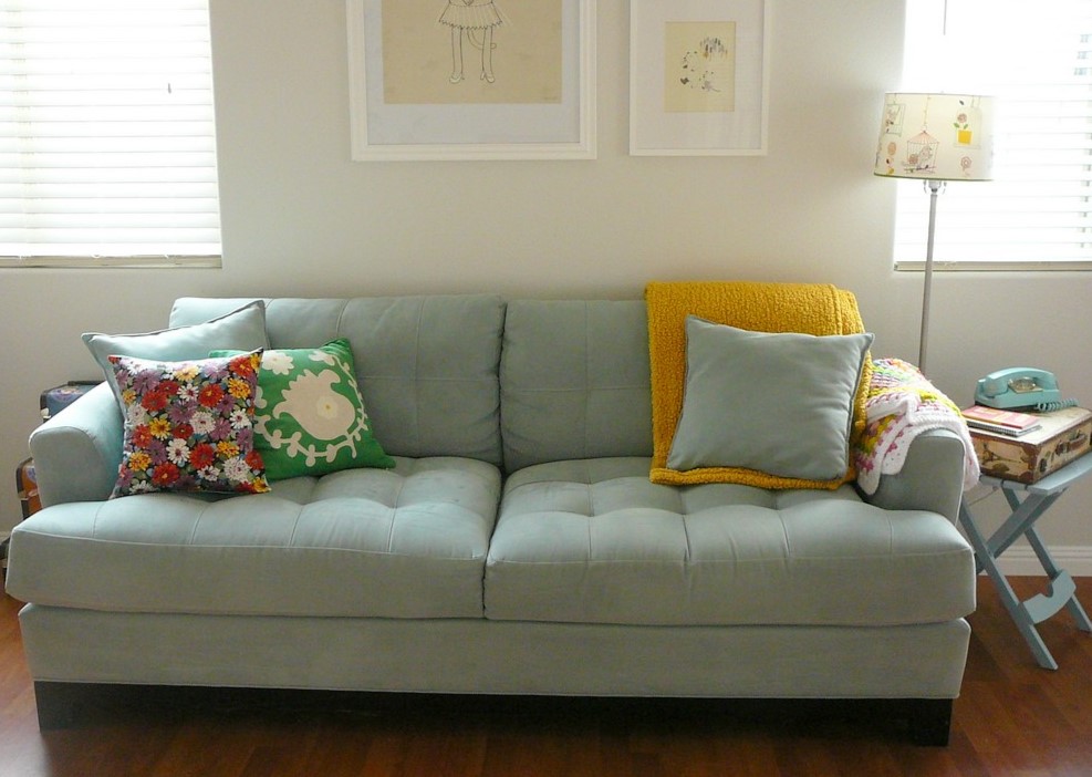 В детской комнате диван можно украсить подушками с яркими рисунками