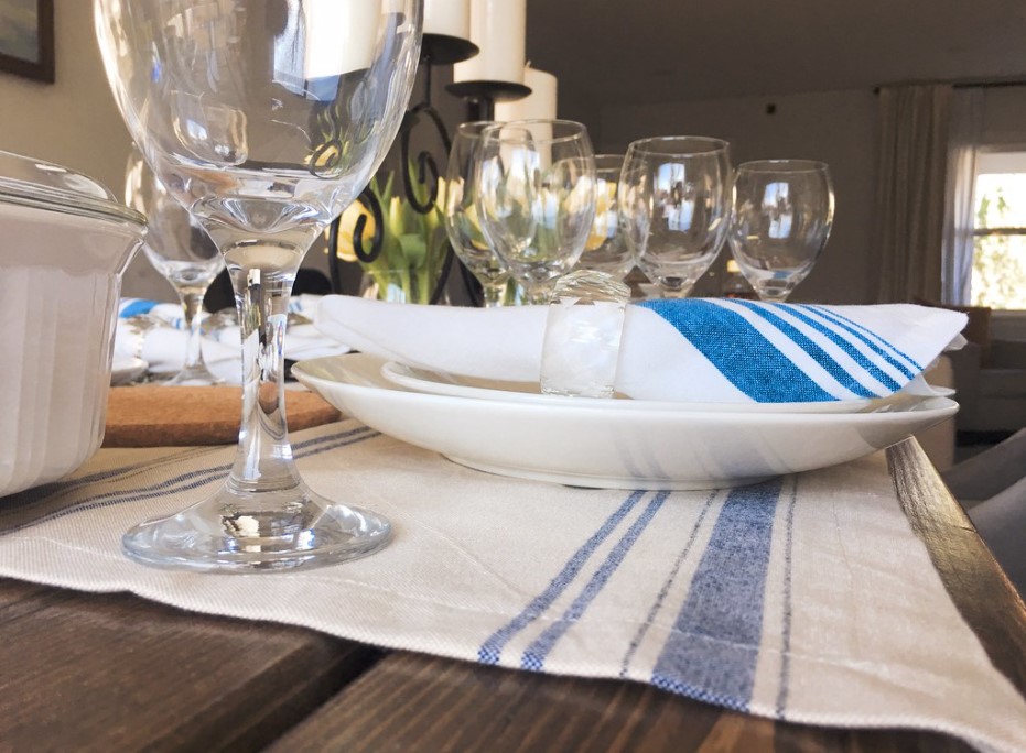 Для сервировки в скандинавском стиле можно использовать белые салфетки с синими полосами
