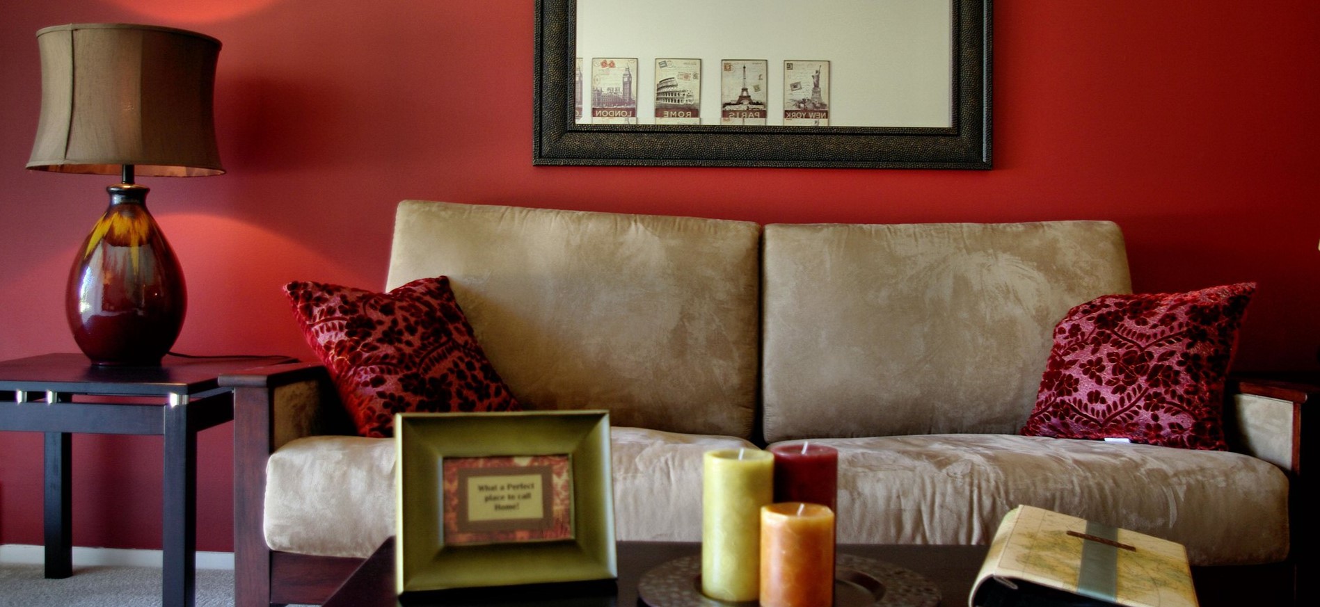 На бежевом диване можно разместить красные подушки под цвет стен