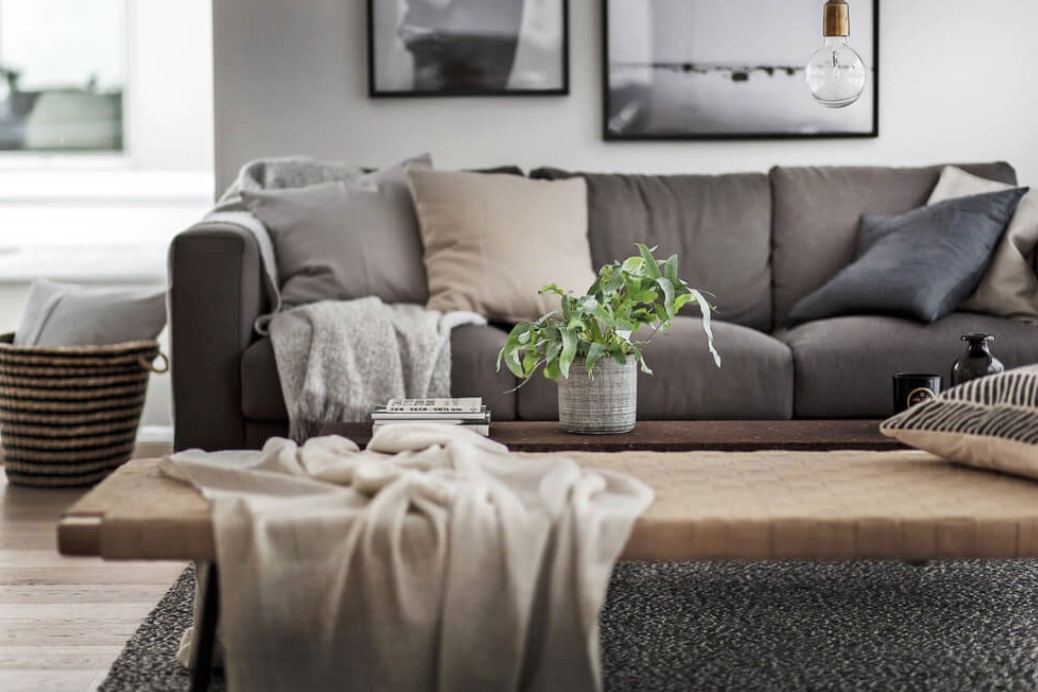 Украсить диван в гостиной можно пледом и небольшими подушками