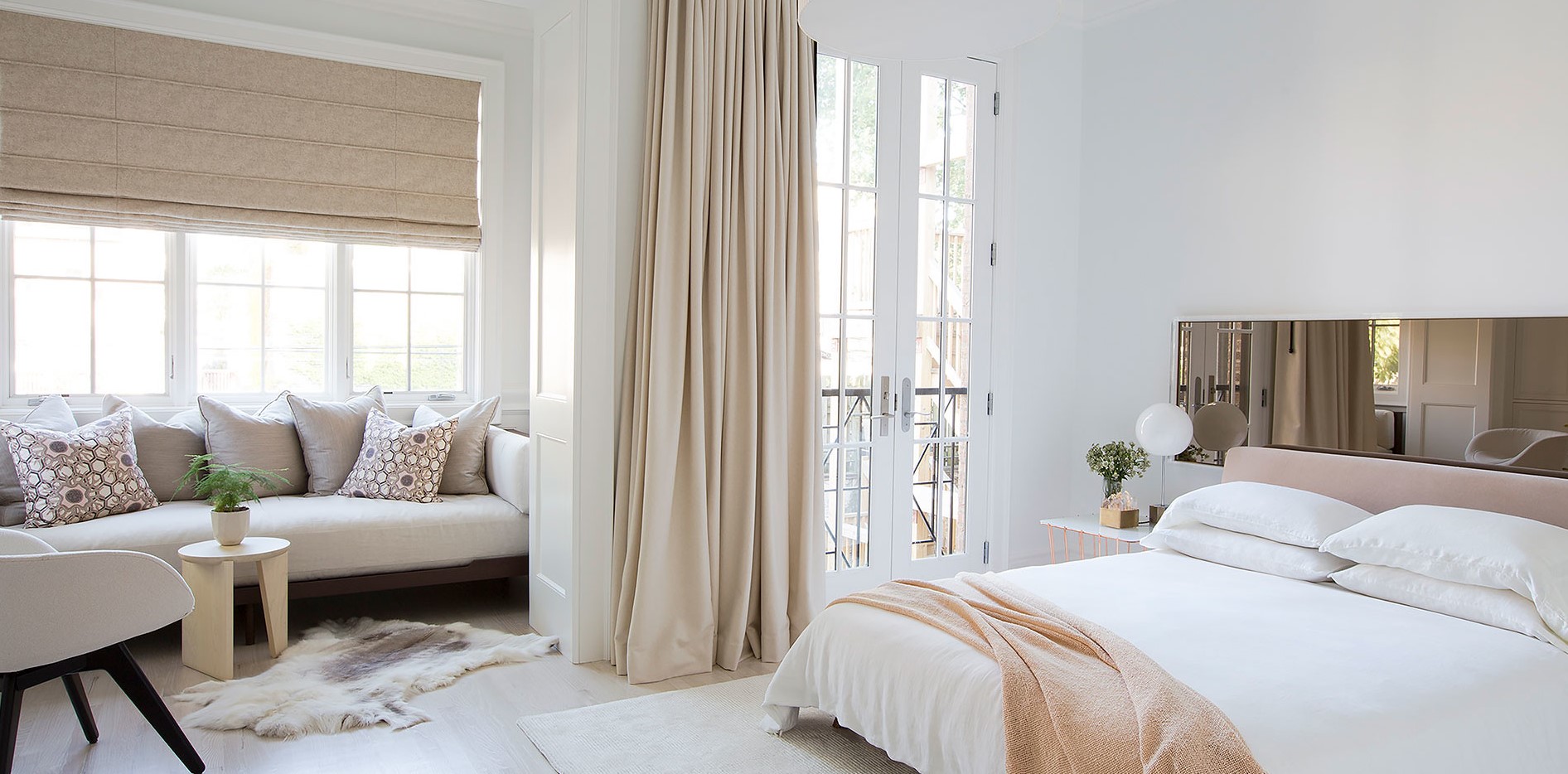 Возле окна в спальне можно поставить небольшой диван для отдыха
