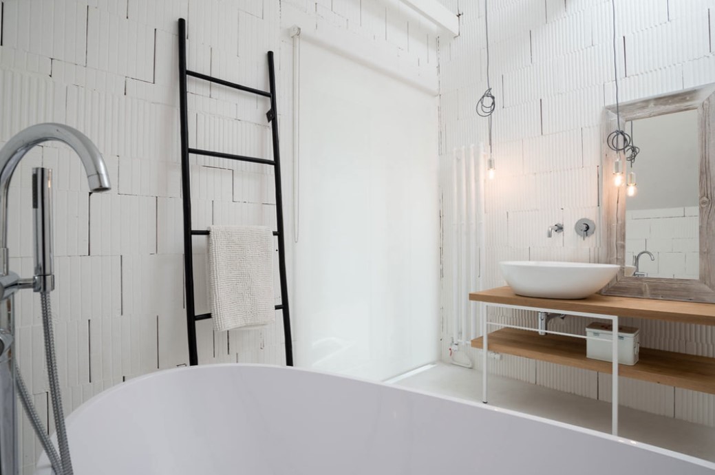 В белой ванне в качестве акцента можно использовать черную декоративную лестницу