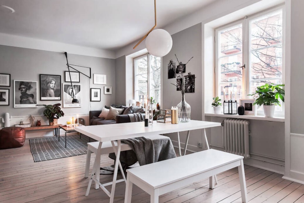 Для современной гостиной идеально подойдет белый стол и серый диван