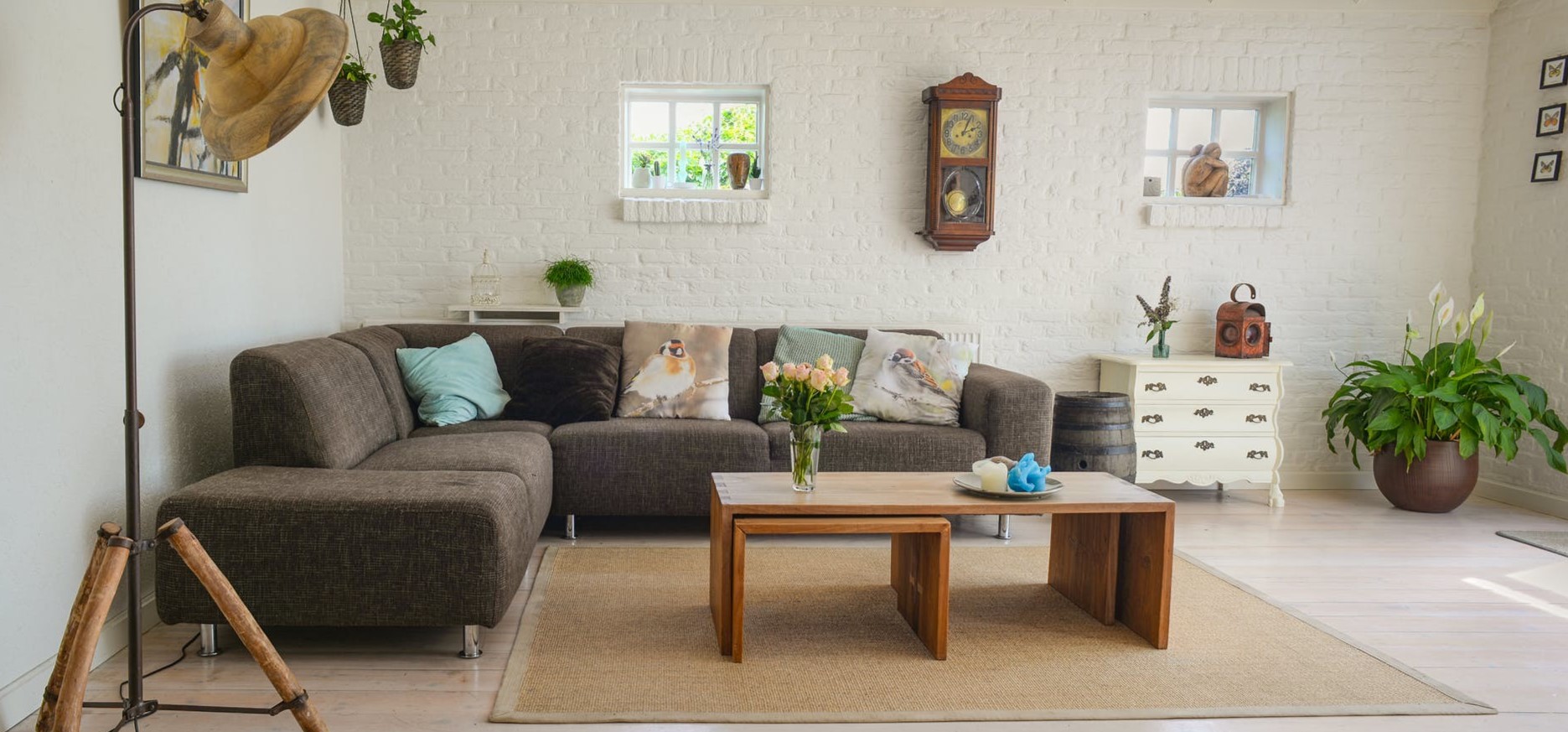 Коричневый диван отлично сочетается с белой кирпичной кладкой в интерьере