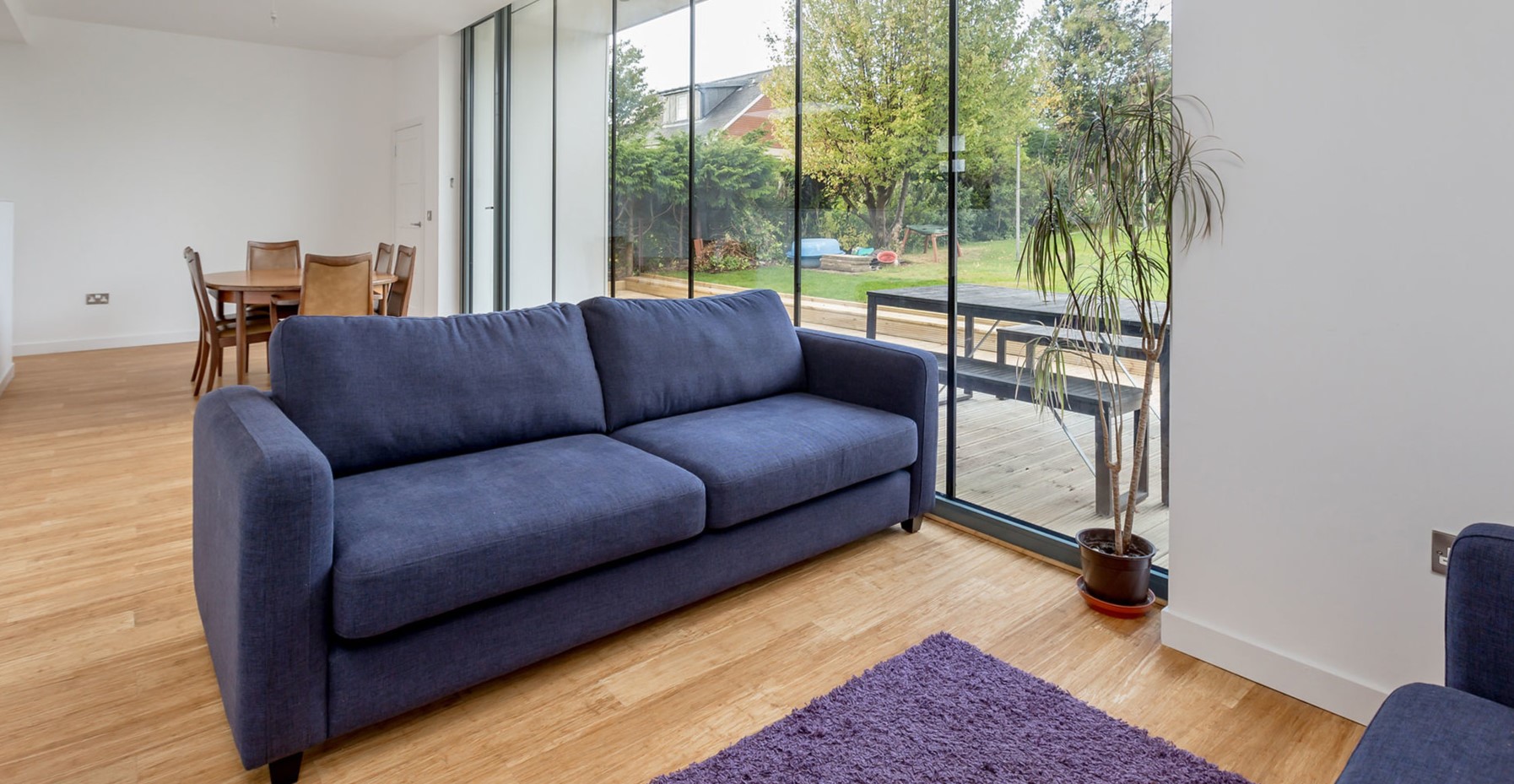 Ортопедический диван с синей обивкой можно использовать в качестве интерьерного акцента в гостиной