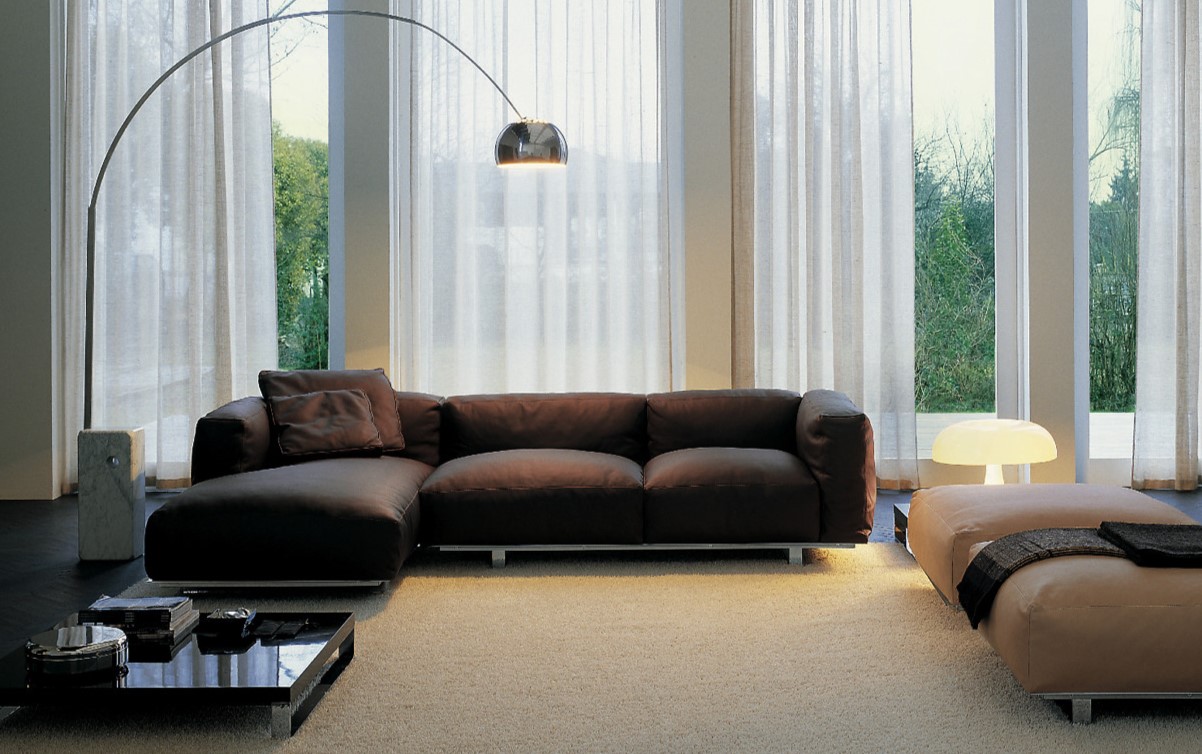 Возле дивана в гостиной можно разместить несколько пуфов и стильный торшер