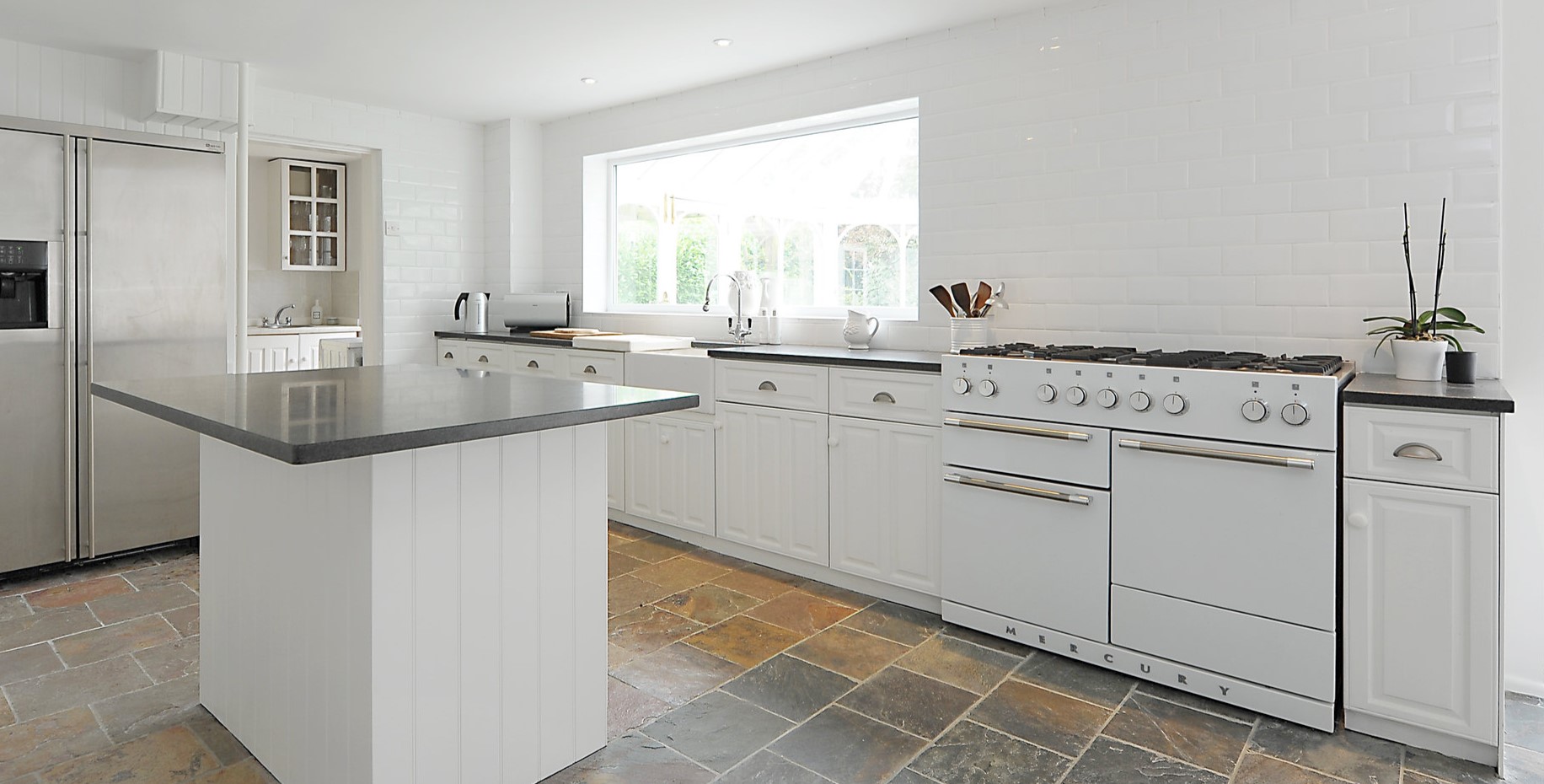 Белая кухонная мебель подойдет для интерьера в стиле минимализм