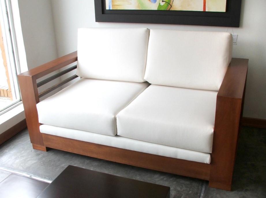 Небольшой раскладной диван можно установить в гостиной возле окна